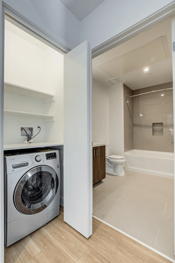 a washer and dryer in a laundry room next to a bathroom